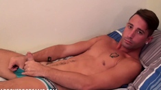 Fit twink Luke Stevens strokes his cock in bed